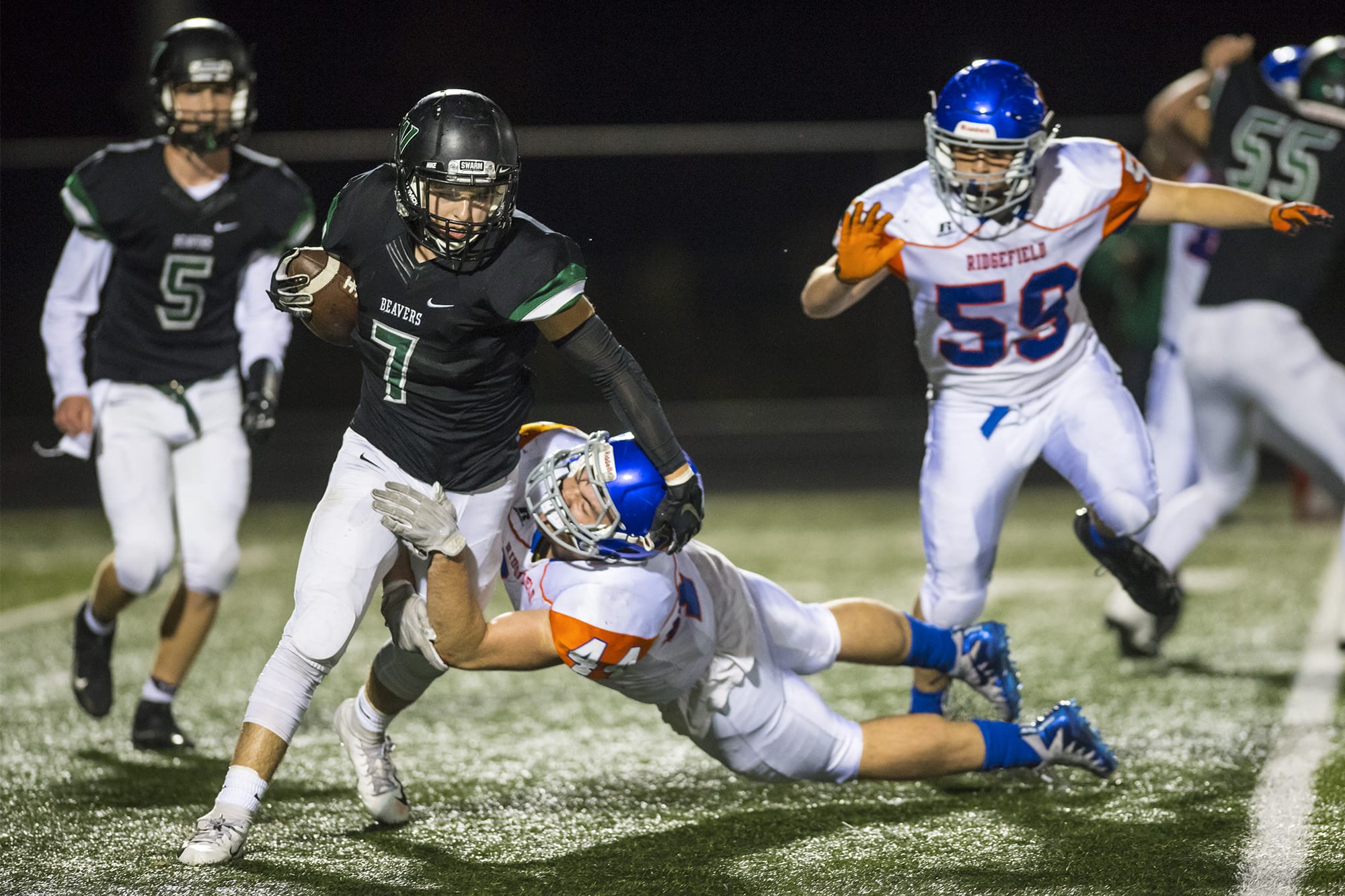 Woodland's Reid Hope breaks a tackle from a Ridgefield defender while running the ball during a game at Woodland High School on Friday night, Oct. 12, 2018.