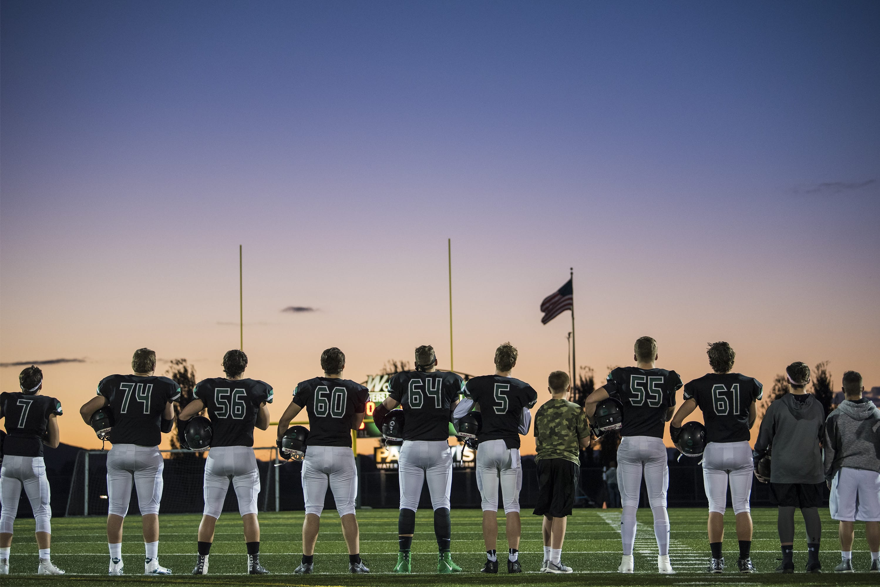 Woodland players listen to the national anthem before their game against Ridgefield at Woodland High School on Friday night, Oct. 12, 2018.