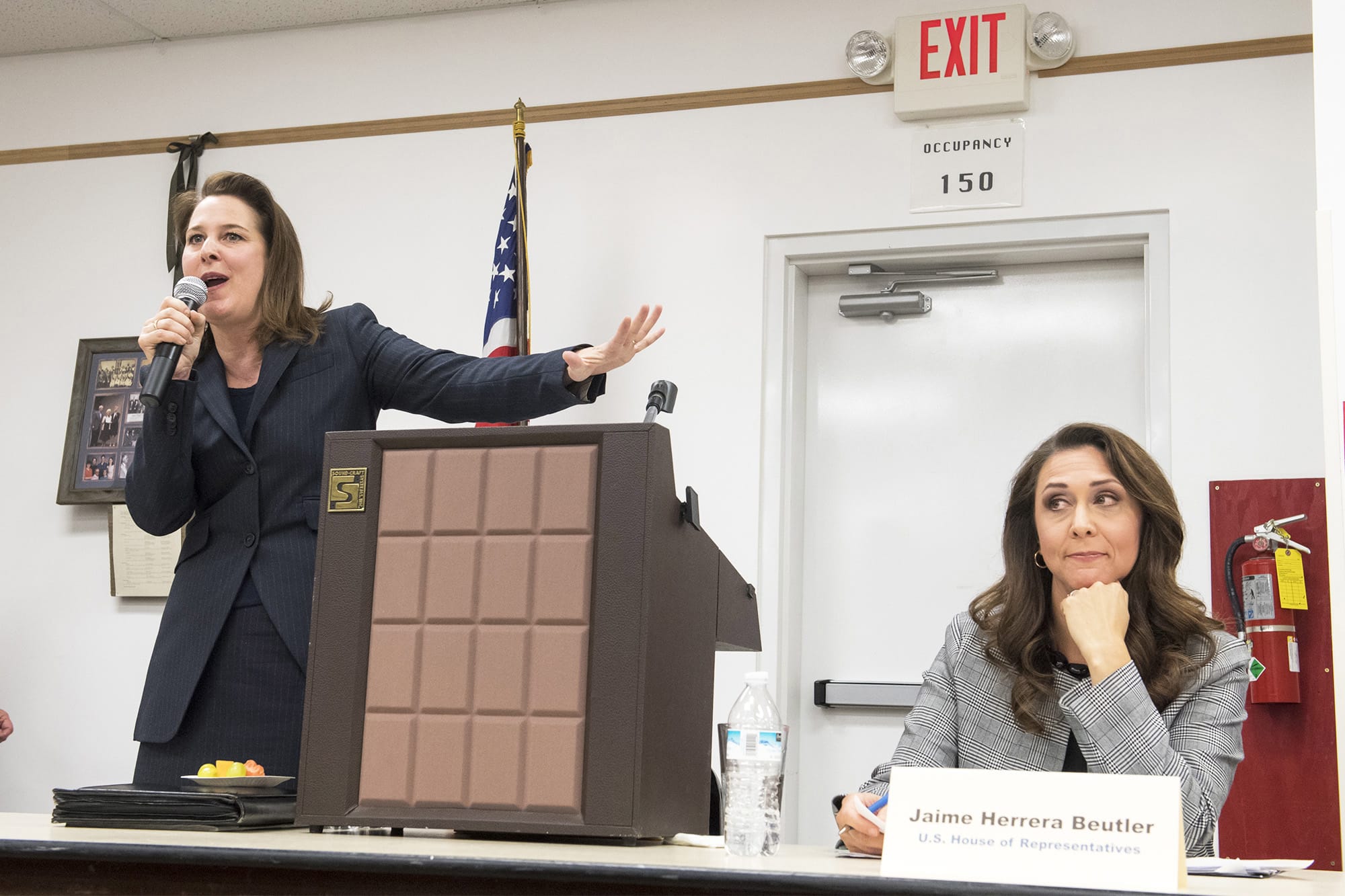 Carolyn Long, Democratic candidate for the 3rd Congressional District, left, gives her closing statement while and Incumbent U.S. Rep. Jaime Herrera Beutler, R-Battle Ground reacts during a forum at the Goldendale Grange Hall Wednesday night.