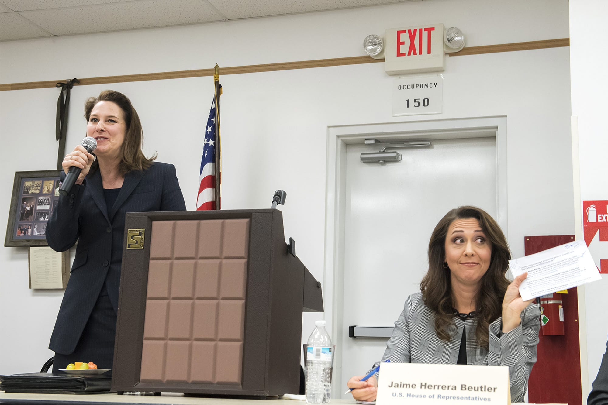 Carolyn Long, Democratic candidate for the 3rd Congressional District, left, speaks about quotes she claims are misrepresented while Incumbent U.S. Rep. Jaime Herrera Beutler, R-Battle Ground, holds up a printout of the quotes in question during a forum at the Goldendale Grange Hall Wednesday night.