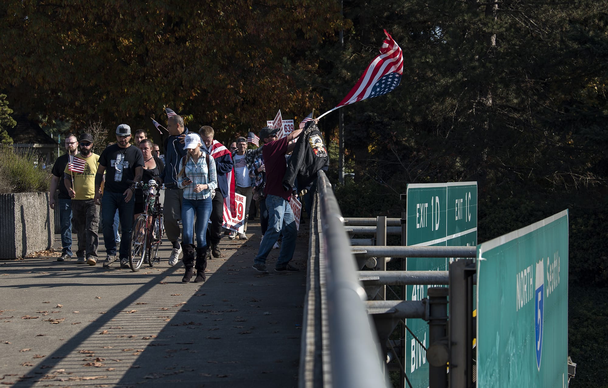 Participants of a rally organized by Patriot Prayer in opposition of Initiative 1639 march down to the East Evergreen Boulevard overpass in Vancouver on Monday afternoon, Oct. 22, 2018.