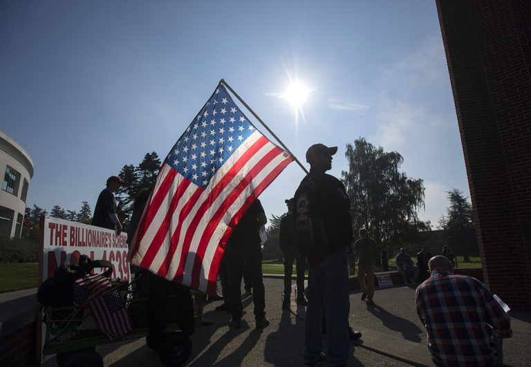 Reggie Axtell of Portland holds his American flag high as he joins other supporters of the second amendment in a rally organized by Patriot Prayer at Clark College on Monday afternoon, Oct. 22, 2018.