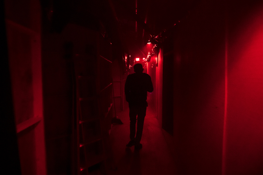 Jason Greeley-Roberts, owner of the Clark County Scaregrounds Haunted House Scream Park, walks through an access corridor behind one of his haunts while checking on the actors on Thursday night, Oct. 25, 2018.