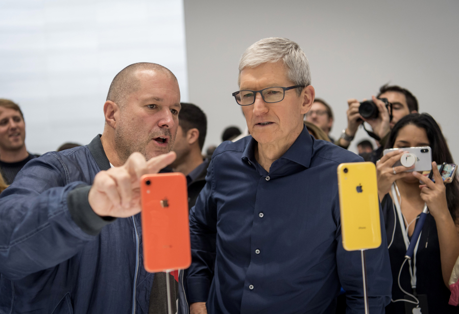 Jony Ive, chief design officer for Apple, left, and Tim Cook, chief executive officer, view a new iPhone during Apple’s annual product event.
