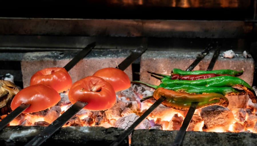 Charred long hots, tomatoes and onions on the grill at Suraya on Monday, Sept. 25, 2018, in Philadelphia, Pa.