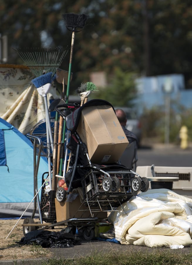 A cart with tools and belongings sits on the street’s edge outside Share House in Vancouver. A new three-year plan will help local officials decide how to spend money available to help homeless people.