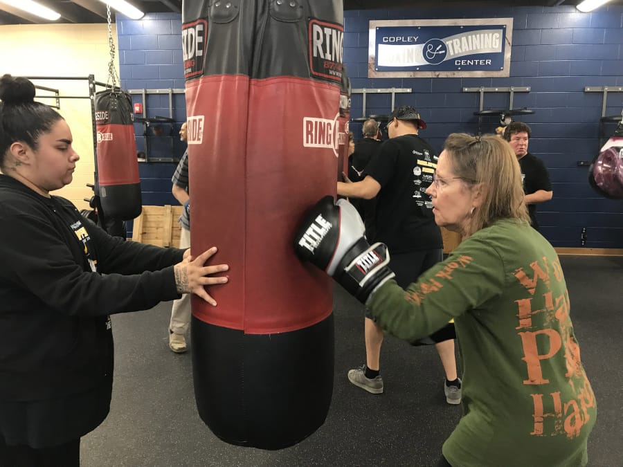 Carol Auer of Batavia, Ill., who has Parkinson’s disease, practices her boxing skills at an open house at the Jesse “The Law” Torres Boxing Club, which is an affiliate with the national Rock Steady Boxing program.