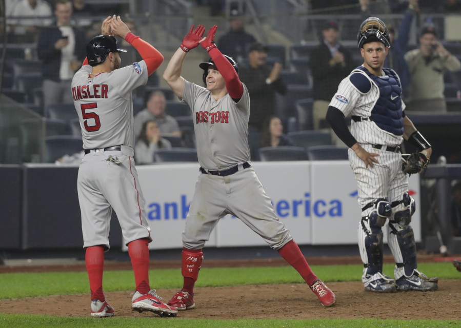 Boston Red Sox’s Brock Holt, center, celebrates with Ian Kinsler (5) after hitting a two-run home run against the New York Yankees during the ninth inning of Game 3 of baseball’s American League Division Series, Monday, Oct. 8, 2018, in New York. Holt hit for the cycle in the Red Sox’s 16-1 win.