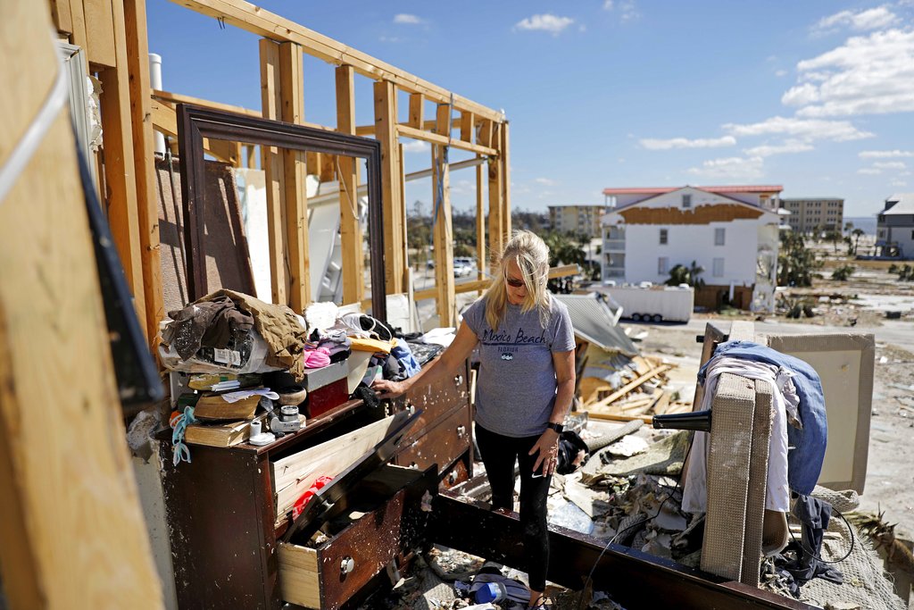 Candace Phillips sifts through what was her third-floor bedroom while returning to her damaged home in Mexico Beach, Fla., Sunday, Oct. 14, 2018, in the aftermath of Hurricane Michael. "We spent 25 years of our marriage working to get here and we're going to stay," said Phillips of her and husband's plans to rebuild.