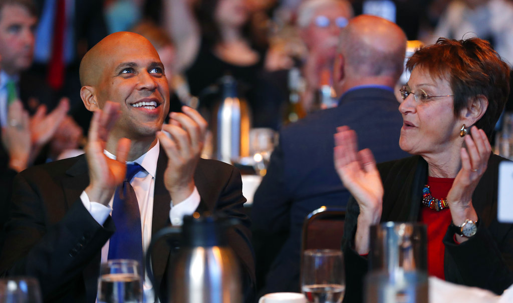 FILE - In this Saturday, Oct. 6, 2018, file photo, U.S. Sen. Cory Booker, D-N.J., sits with former Iowa Lt. Gov. Sally Pederson, right, during the Iowa Democratic Party's annual Fall Gala, in Des Moines, Iowa. Many of the Democratic Party’s most ambitious have begun building relationships in the states most responsible for picking the party’s next presidential nominee. Booker has raised more than $7 million and campaigned across 21 states for other Democratic candidates this midterm season, according to an aide.