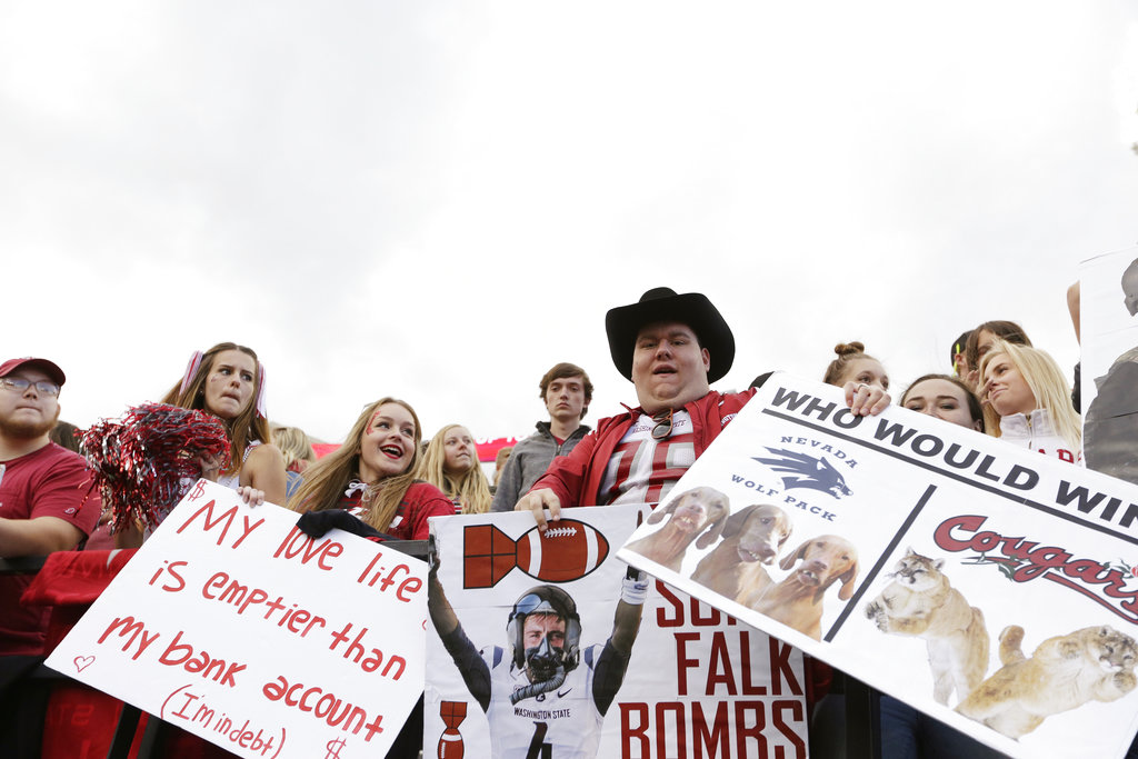FILE - In this Sept. 23, 2017, fie photo, Washington State fans hold signs during the second half of an NCAA college football game between Washington State and Nevada in Pullman, Wash. After 15 years of the Washington State flag begin a backdrop fixture to every “College GameDay” broadcast, ESPN is coming to Washington State on Saturday.