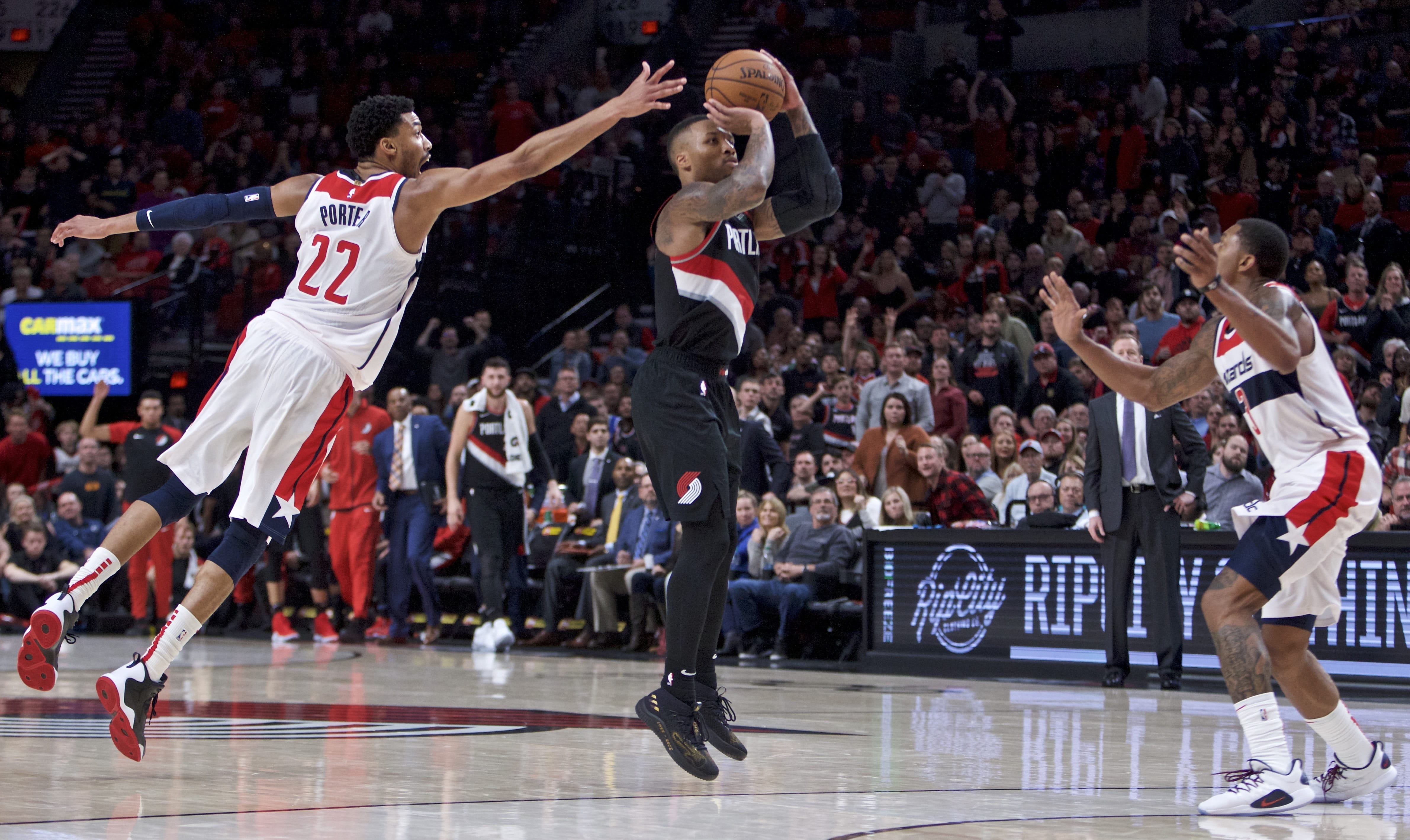 Portland Trail Blazers guard Damian Lillard, center, shoots over Washington Wizards forward Otto Porter Jr., left, and guard Bradley Beal, right, during the second half of an NBA basketball game in Portland, Ore., Monday, Oct. 22, 2018.