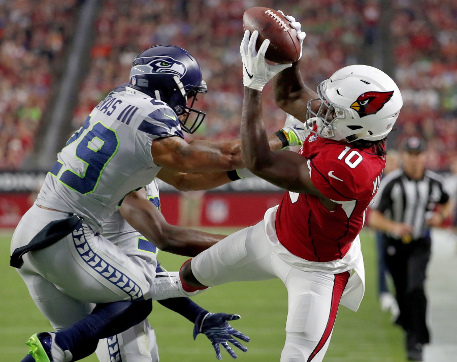 Arizona Cardinals wide receiver Chad Williams (10) makes the catch as Seattle Seahawks defensive back Earl Thomas (29) defends during the first half of an NFL football game, Sunday, Sept. 30, 2018, in Glendale, Ariz.