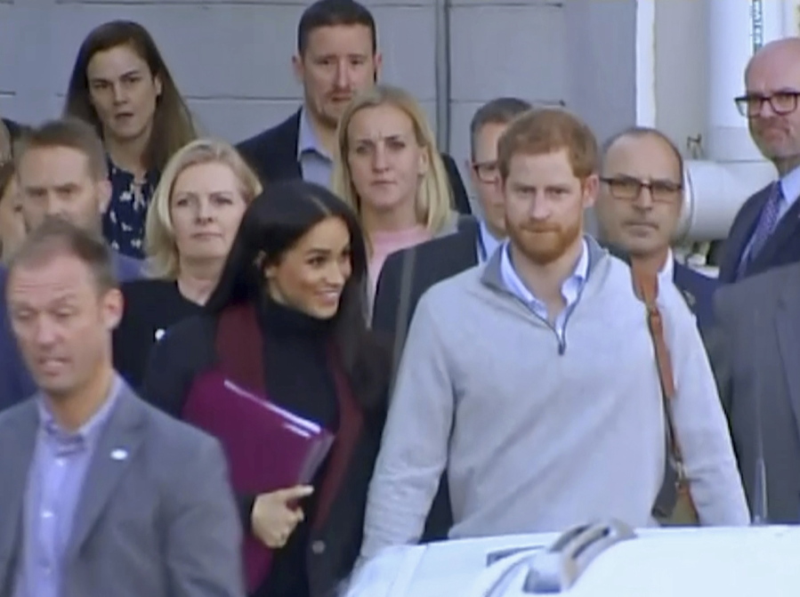 Britain’s Prince Harry, center right, and his wife Meghan, center left, Duke and Duchess of Sussex, approach a car at an airport in Sydney, Monday, Oct. 15, 2018. Prince Harry and his wife Meghan arrived in Sydney on Monday, a day before they officially start a 16-day tour of Australia and the South Pacific. Kensington Palace says Prince Harry and Meghan the Duchess of Sussex are expecting a child in the spring.