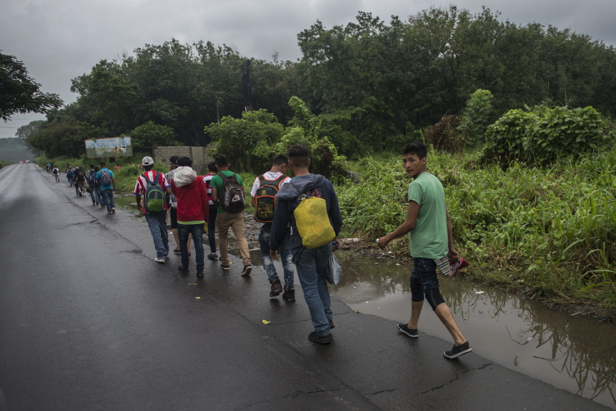 Honduran migrants walk along a highway Thursday in Cocales, Guatemala.