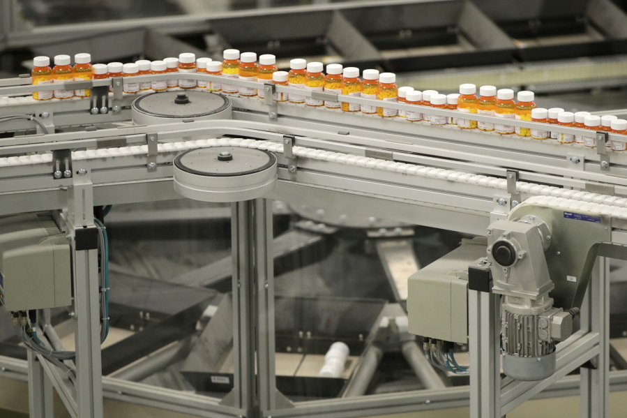 Bottles of medication travel along on a belt at the Express Scripts mail-in pharmacy warehouse in Florence, N.J.