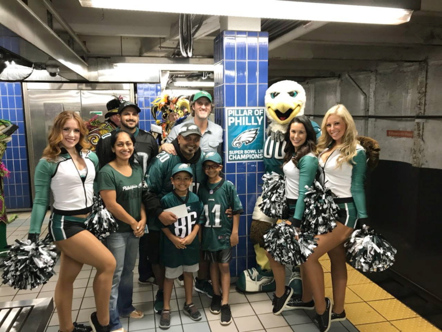 Philadelphia Eagles fan Jigar Desai poses with his family, friends and members of the Philadelphia Eagles Cheerleaders in front of the subway pillar he ran into earlier this year at Ellsworth Station on the Broad Street subway line in Philadelphia. The moment in the spotlight isn’t over yet for Desai who stumbled into fame as a viral video star after running into the subway pillar. Desai is now the subject of an NFL digital short feature, shot ahead of the Oct. 28 Eagles game against the Jacksonville Jaguars in London.
