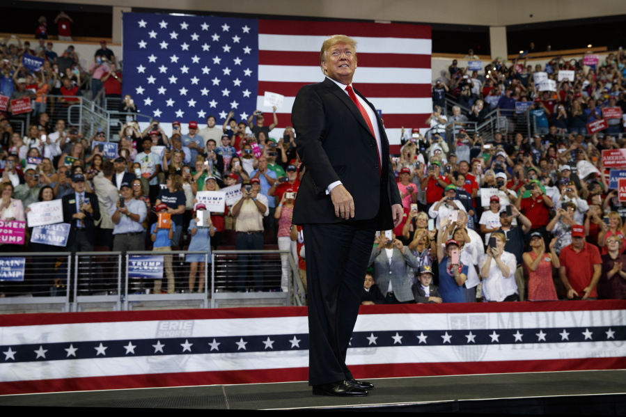 FILE - In this Oct. 10, 2018, file photo, President Donald Trump arrives to speak at a campaign rally at Erie Insurance Arena, in Erie, Pa. President Donald Trump’s campaign rallies once had the feel of angry, raucous grievance sessions. More than 350 rallies later, gone is the darkness, the crackling energy, the fear of potential violence as supporters and protesters face off. Perish the thought, have Donald Trump’s rallies gone mainstream?