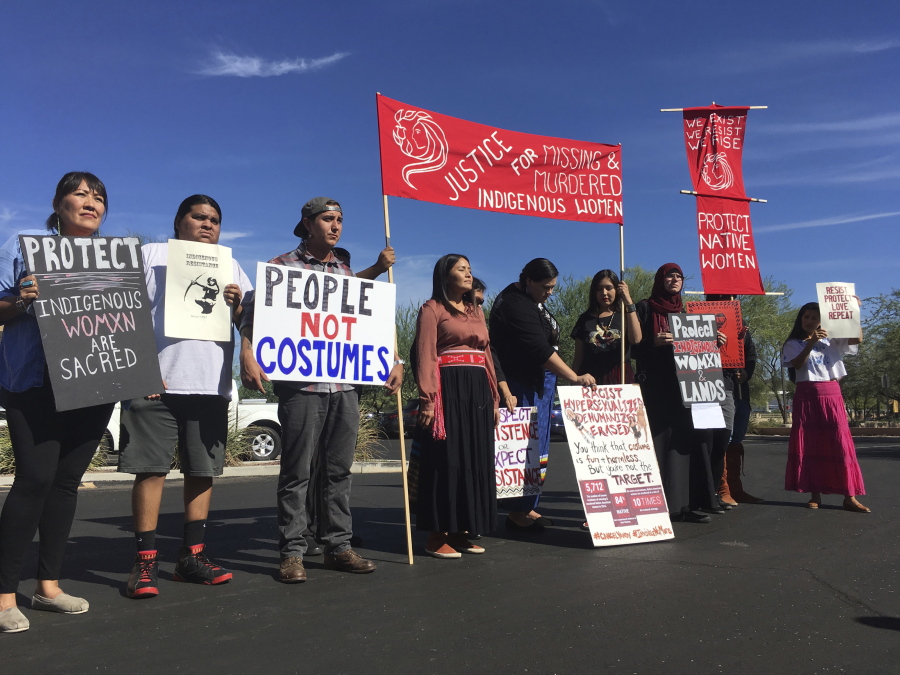 Native American protesters stand outside the Phoenix office of Yandy.com, a retailer of “sexy Native American” costumes on Wednesday. For some ethnic and racial groups, Halloween has long been haunted by costumes that perpetuate stereotypes and instances of cultural appropriation.