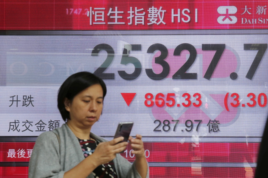 A woman walks past an electronic board showing Hong Kong share index outside a bank In Hong Kong, on Thursday. Asian markets tumbled on Thursday, after Wall Street slumped on a heavy selling of technology and internet stocks.