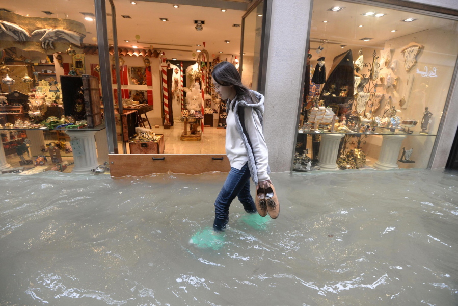 A woman walks in a flooded street of Venice, Italy, Monday.