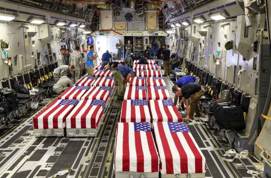 Flag-draped transfer cases containing remains of unidentified service members sit inside a C-17 Globemaster plane after arriving at Offutt AFB in Bellevue, Neb., on Sept. 13 The remains were gathered in Europe.