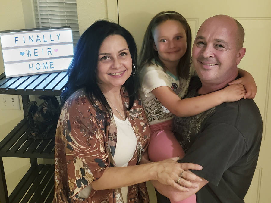 The Weir family, from left, Vennita, Athena and Bill, is seen at home last month in Albuquerque, N.M.