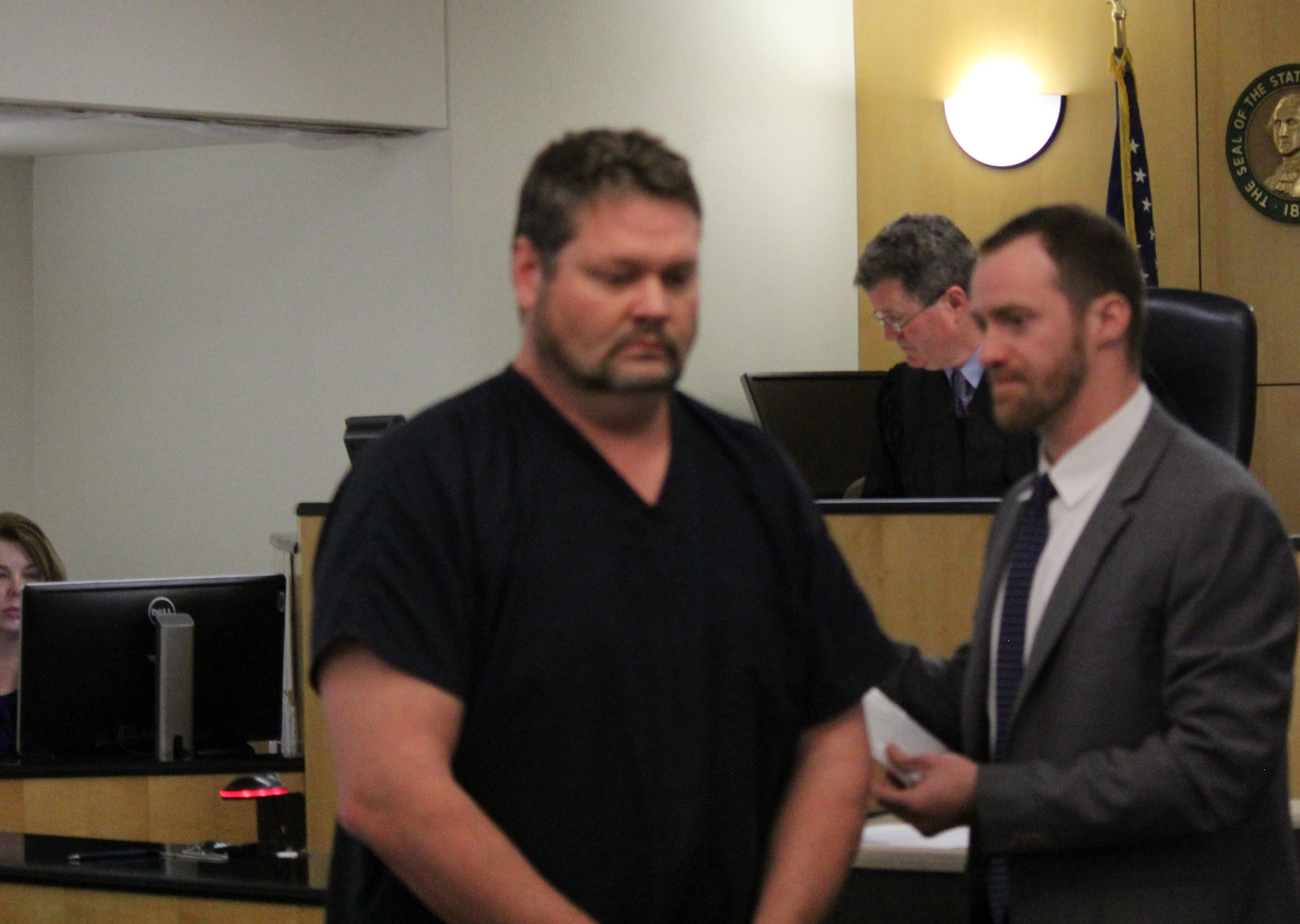 Nicholas A. Clark (center) appears in Clark County Superior Court on Monday to face charges of possessing depictions of a minor engaged in sexually explicit conduct. A deputy prosecutor said Clark coached youth football in the county.