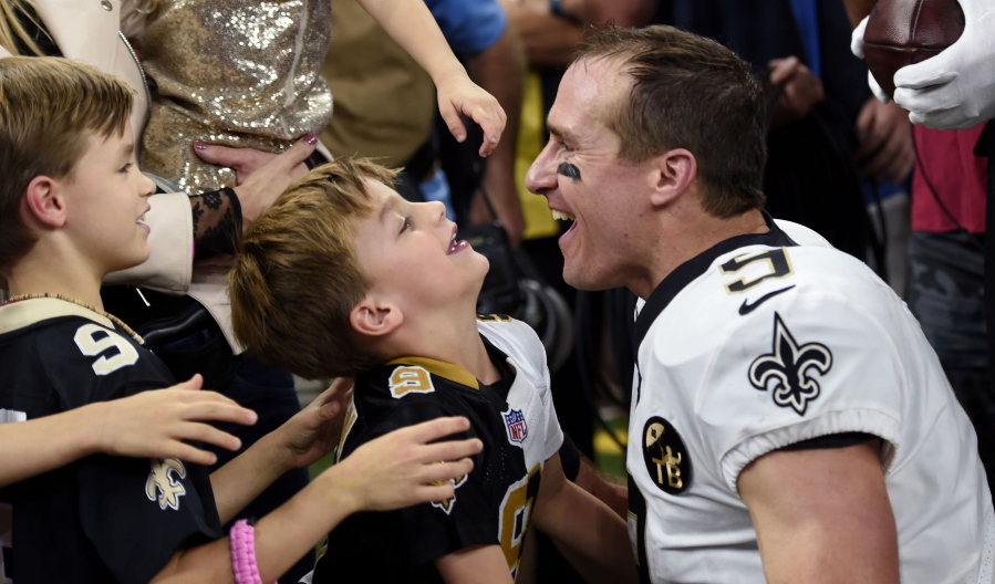 New Orleans Saints quarterback Drew Brees (9) greets his family after he broke the NFL all-time passing yards record in the first half of an NFL football game against the Washington Redskins in New Orleans, Monday, Oct. 8, 2018.