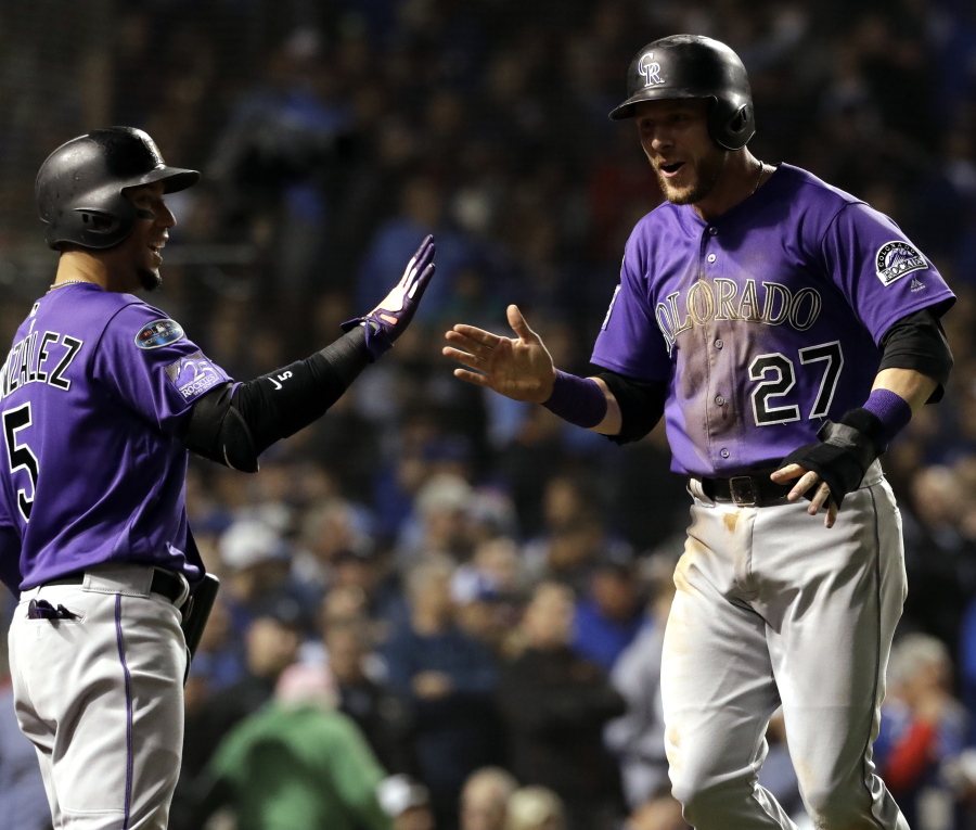 Colorado Rockies’ Trevor Story, right, celebrates with Carlos Gonzalez after scoring the go-ahead run on a hit by Tony Wolters in the 13th inning against the Chicago Cubs. Nam Y.