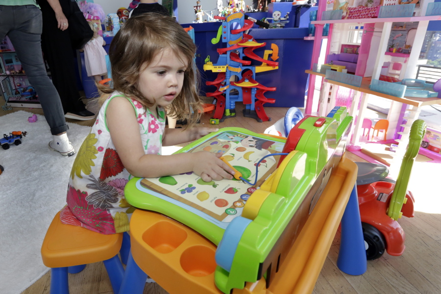 A 3-year-old plays with a V-Tech Explore and Write Activity Set at the Walmart Toy Shop event Aug. 30 in New York. Walmart says 30 percent of its holiday toy assortment will be new.