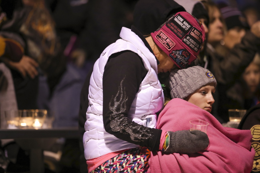 People attend a gathering during a moment of silence for Jayme Closs at the Barron High School Football Stadium on Monday. Authorities revealed they’re looking for two vehicles in connection with the disappearance of the Wisconsin girl whose parents were gunned down last week, calling on hundreds of volunteers to resume a ground search. State, local and federal investigators have been searching for Closs since early Oct. 15, when deputies discovered someone had broken into the family’s rural Barron home and shot her parents to death.