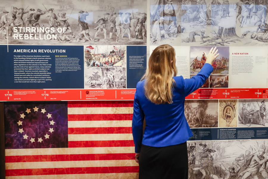 A staff member browses a display during a limited media availability at the National Veterans Museum and Memorial, Monday, Oct. 15, 2018, in Columbus, Ohio. A sweeping new museum in America's heartland honors the unifying experiences of U.S. military veterans outside the traditional trappings of military museums and war memorials. The 50,000-square-foot museum, which opens Oct. 27 in Columbus, Ohio, aims to honor, inspire, connect and educate with unique interactive experiences.