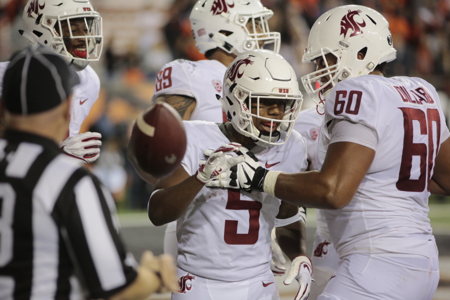 Washington State's Travell Harris (5) celebrates with teammate Andre Dillard (60) after making a touchdown during the fourth quarter of an NCAA college football against Oregon State in Corvallis, Ore., Saturday, Oct. 6, 2018. (AP Photo/Timothy J.