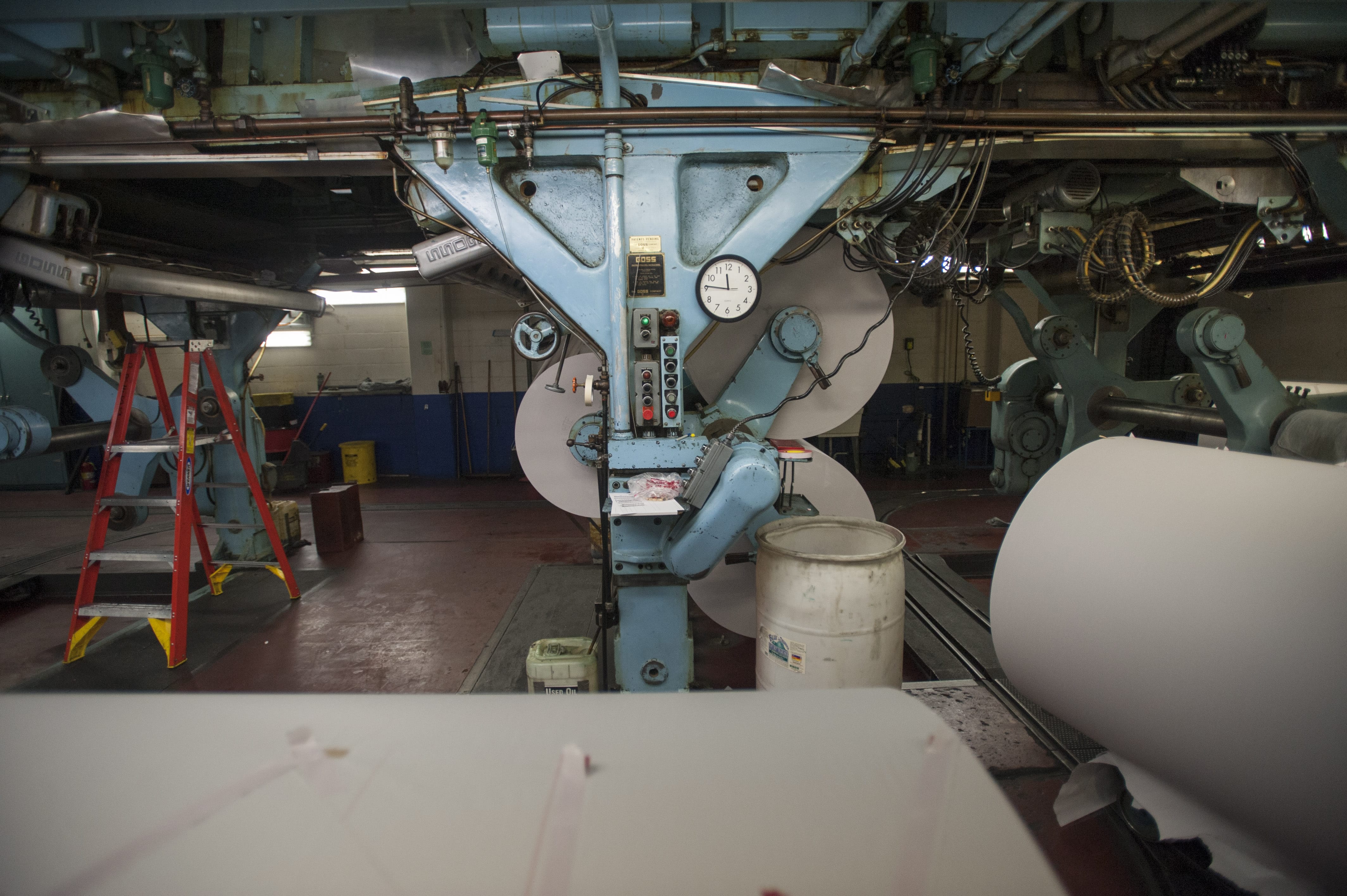 Newsprint arrives on big rolls, which are attached to the underside of The Columbian's Goss Metro offset press.