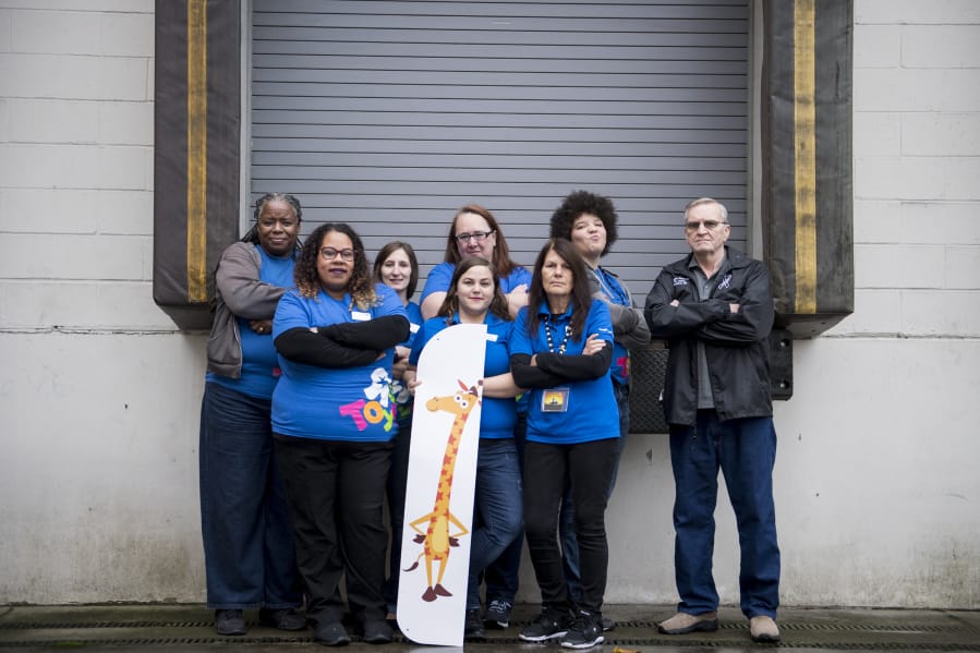 Michelle Perez, center front, and other former Toys R Us employees stand in front of the loading dock of their former Jantzen Beach store. Perez has become an activist on behalf of the 33,000 Toys R Us workers who were displaced after the owners of the longtime retail chain announced its closure this summer.