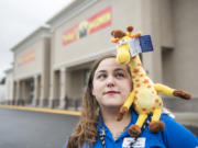 Michelle Perez, a former Toys R Us employee, stands with a toy version of Geoffrey the Giraffe, the mascot for the longtime retail chain that was closed for good this summer.