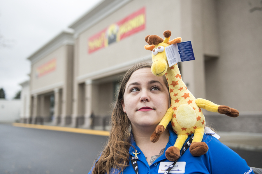 Michelle Perez, a former Toys R Us employee, stands with a toy version of Geoffrey the Giraffe, the mascot for the longtime retail chain that was closed for good this summer.