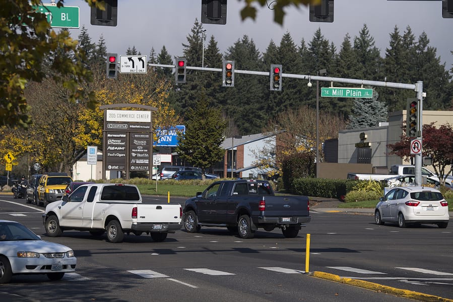 Motorists run through a red light at the intersection of Southeast Mill Plain Boulevard and Chkalov Drive. About a decade ago, the city considered putting a red-light camera at the intersection but never did. Since then, both the city and the county have opted for a different approach to policing red-light scofflaws.