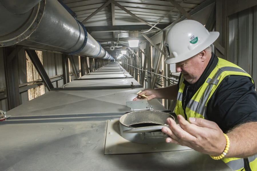 John Lindgren, export terminal director at United Grain, looks into a portion of a conveyor belt transporting grain from a ship into a storage containers at the Port of Vancouver.