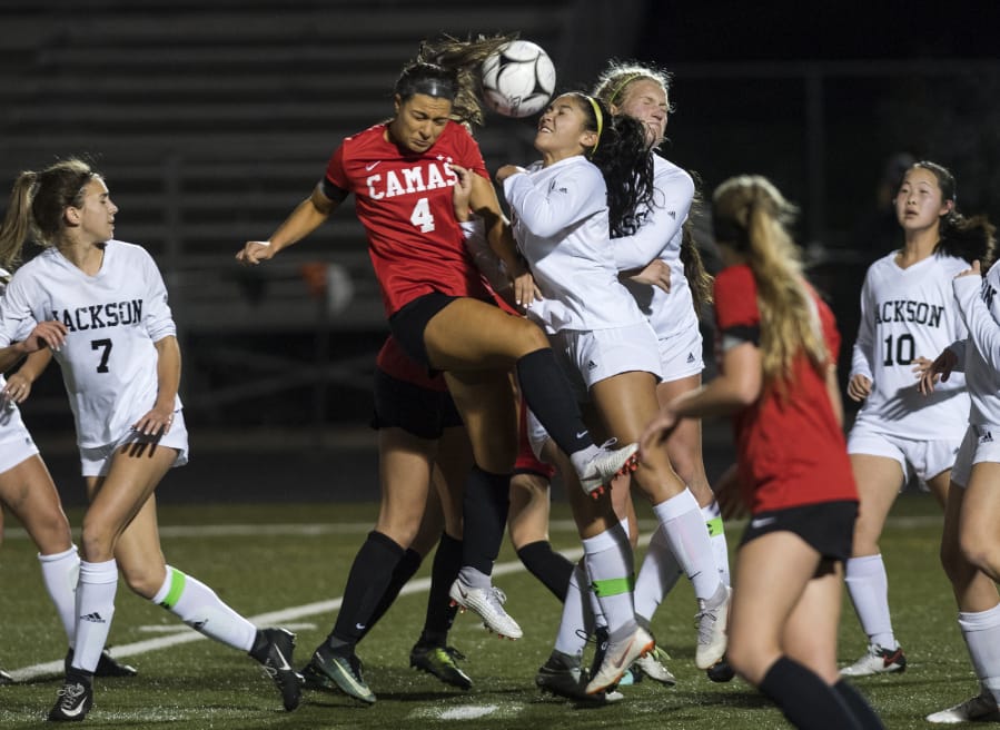 Camas’ Maddie Kemp (4) collides with Jackson’s Peyton Manalo (8) for a header during the first round of the 4A state playoffs at Doc Harris Stadium.