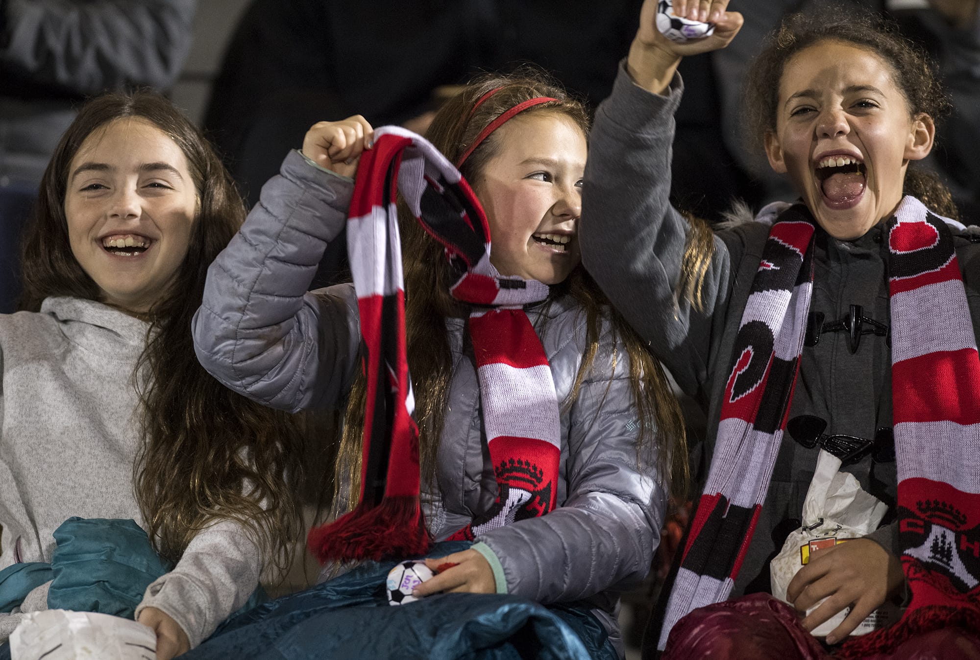 Lila McCarthy, 10, left, Eliana Gibson, 9, center, and Lauren Hood, right, 10, all of Camas, cheer on the Papermakers during the first round of the 4A state playoffs at Doc Harris Stadium in Camas on Wednesday, Nov. 7, 2018. Camas won 1-0.
