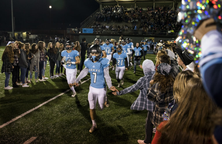 Hockinson's fans surround Nick Charles (7) and his teammates as they run onto the field after halftime during the first round of the 2A state football playoffs against Washington in Battle Ground on Friday, Nov. 9, 2018. Hockinson defeated Washington 47-14.