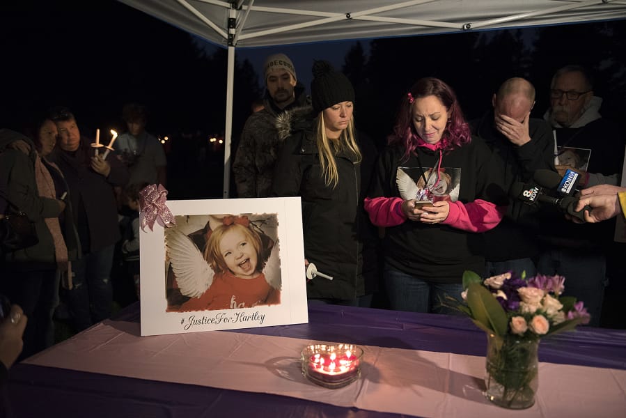 Nataasha Luchau, center, with pink sleeves, mother of Hartley Anderson, 5, reads a statement from the family to the media from her cellphone before a candlelight vigil in memory of her daughter Friday evening at LeRoy Haagen Memorial Park in Vancouver.