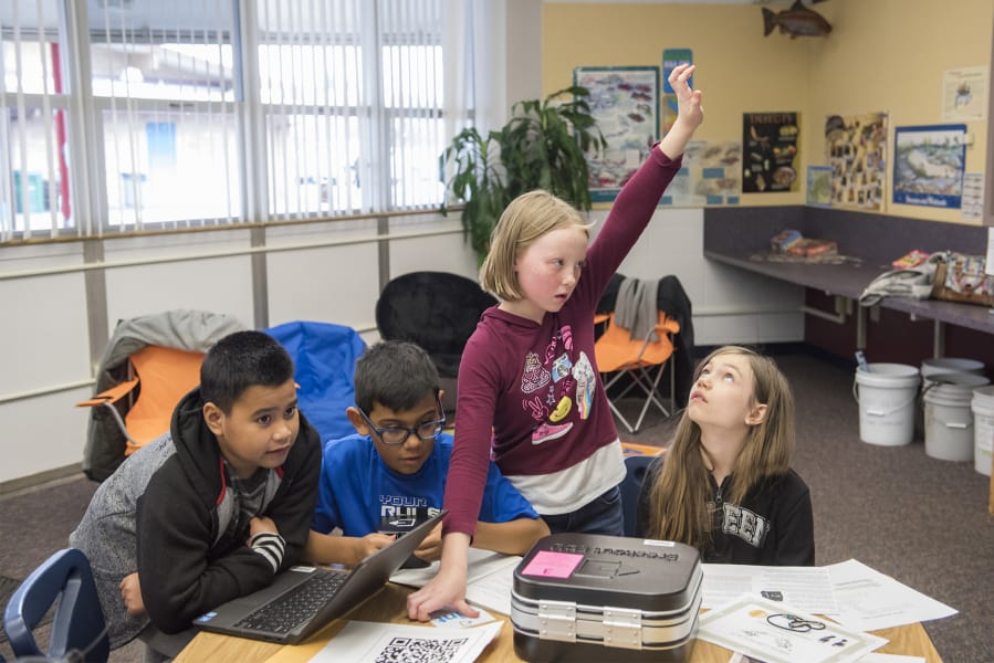 Fifth-graders Dean-Anthony Elesha, from left, Sebastian Herrera Cruz, Chasity Cherrington and Lily Podboy ask for help while working on a history-themed puzzle box earlier this month at Sifton Elementary School. Students used a series of puzzles to find the solutions to a variety of combination locks.