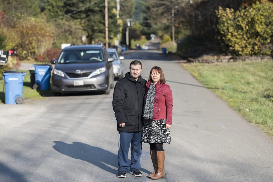 Calin and Marinela Buzas stand in the street between their home and the proposed development on Northeast 62nd Avenue.