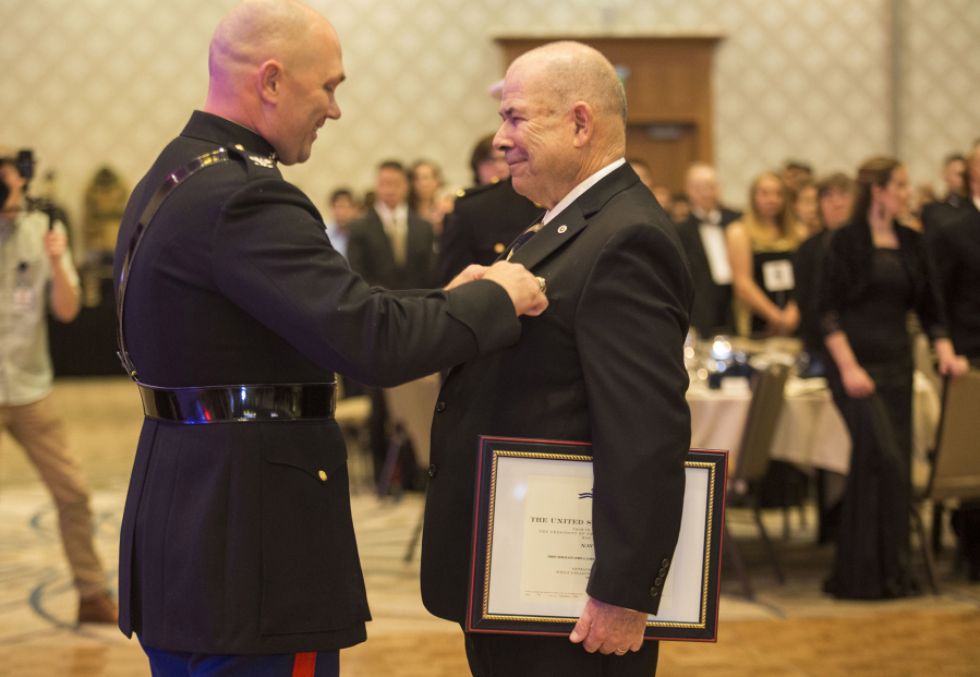Fifty years after Ret. Marine 1st Sgt. John Lord, right, led his platoon through an ambush in the Vietnam War, he is presented with the Navy Cross by  Col. Jay Wylie at the Marine Corps Birthday Ball at the Hilton Vancouver Washington on Saturday.