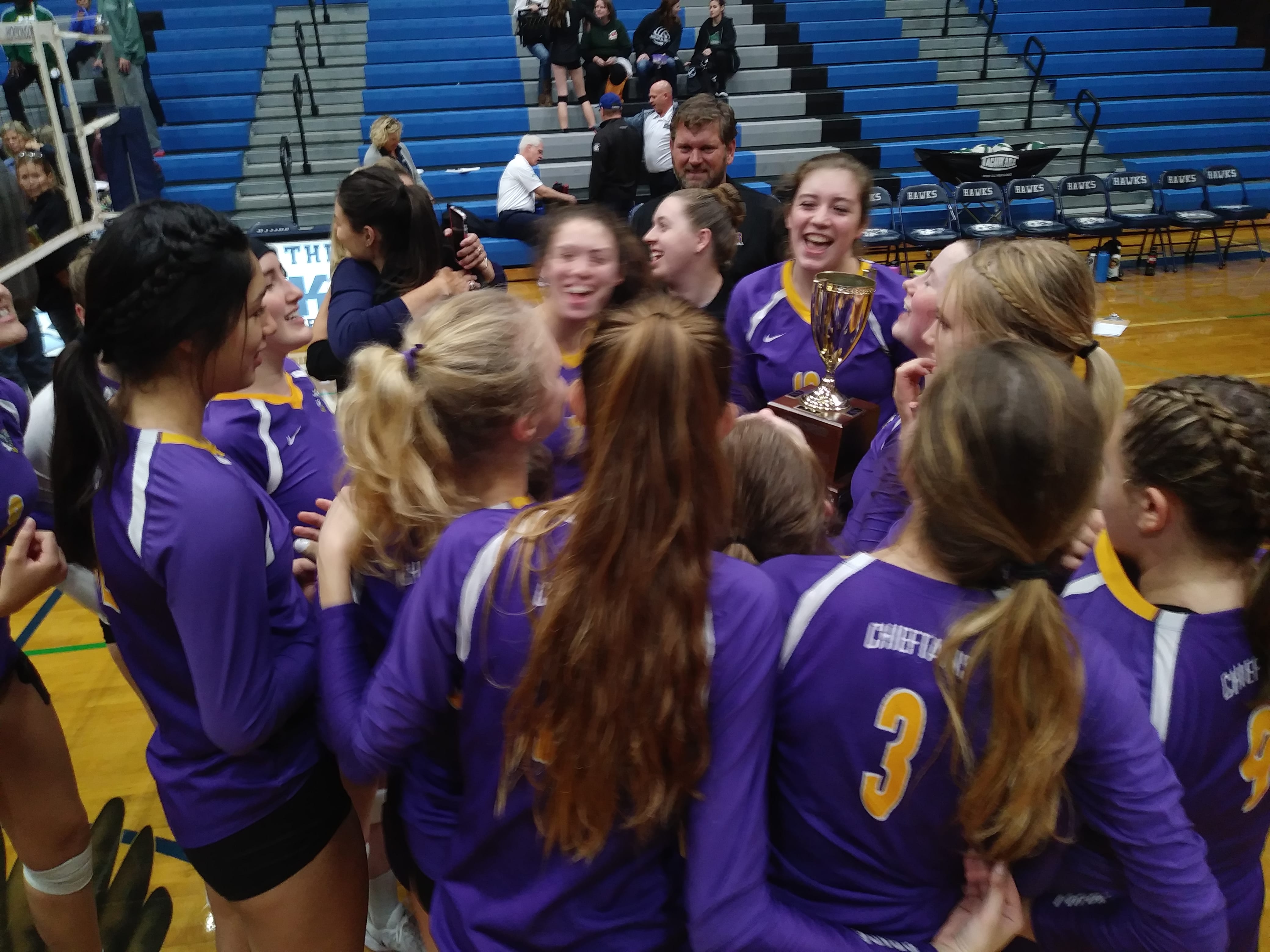 The Columbia River volleyball team gathers around the district championship trophy after taking the title Saturday in Hockinson (Tim Martinez/The Columbian)