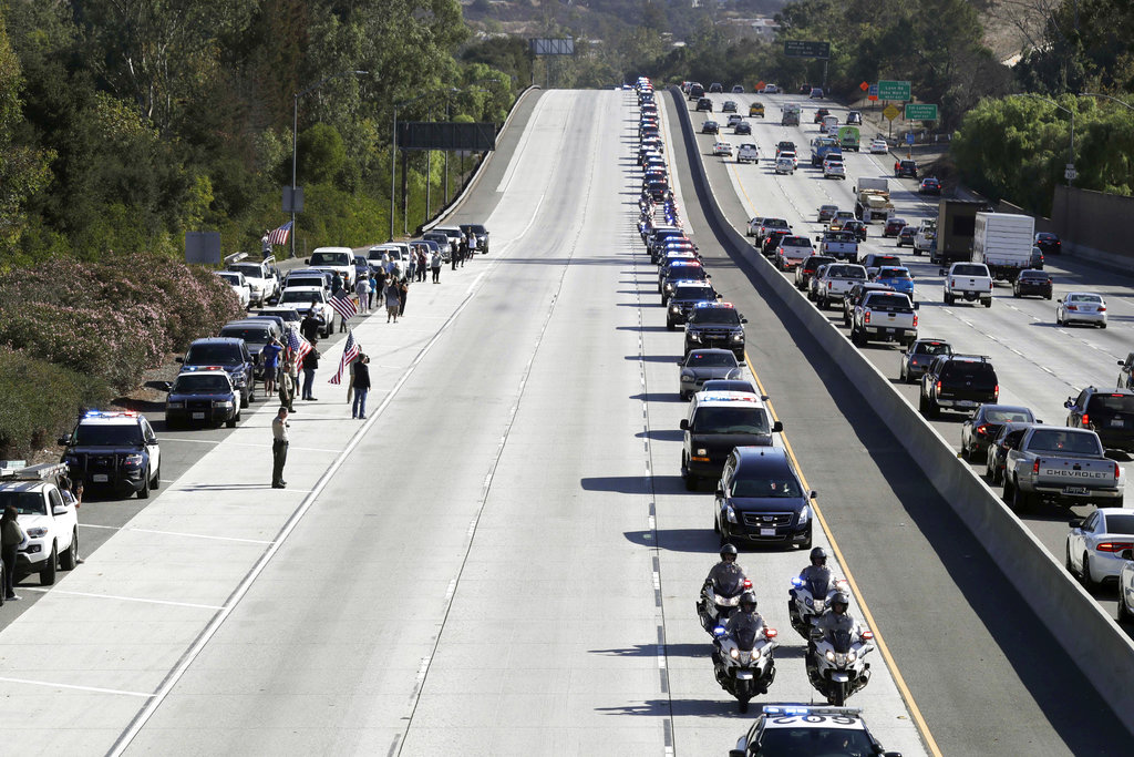 A law enforcement motorcade, providing an escort for a hearse carrying the body of Ventura County Sheriff's Sgt. Ron Helus, makes its way northbound on Highway 101 Thursday, Nov. 8, 2018, in Newbury Park, Calif. Helus was fatally shot while responding to a mass shooting at a country music bar in Southern California.