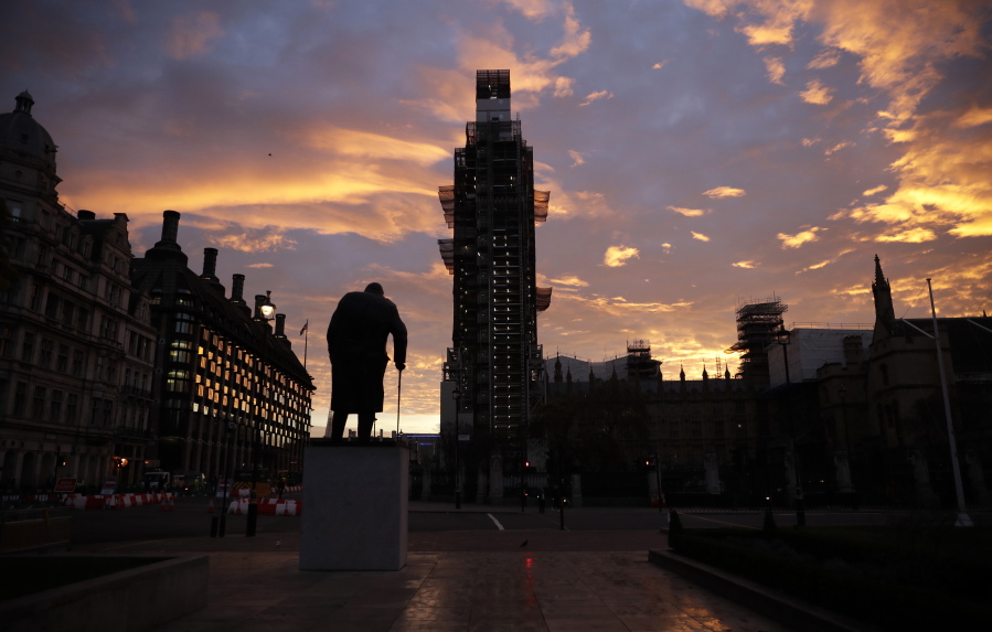 The sun rises as seen in Parliament Square with the statue of former Prime Minister Winston Churchill in the foreground in London on Wednesday. British Prime Minister Theresa May will try to persuade her divided Cabinet on Wednesday that they have a choice between backing a draft Brexit deal with the European Union or plunging the U.K. into political and economic uncertainty.